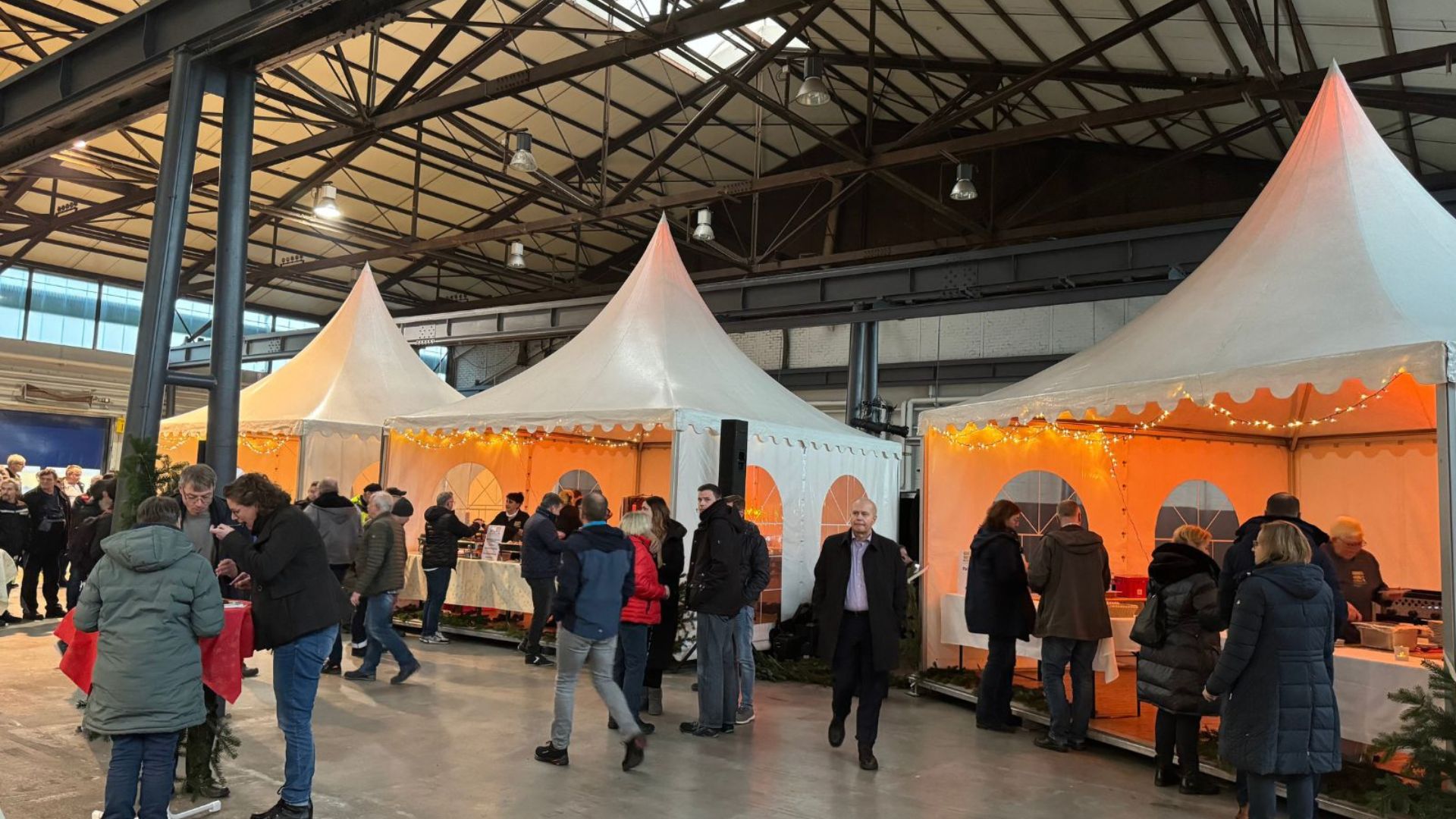 Menschen besuchen eine festlich beleuchtete Indoor-Weihnachtsfeie