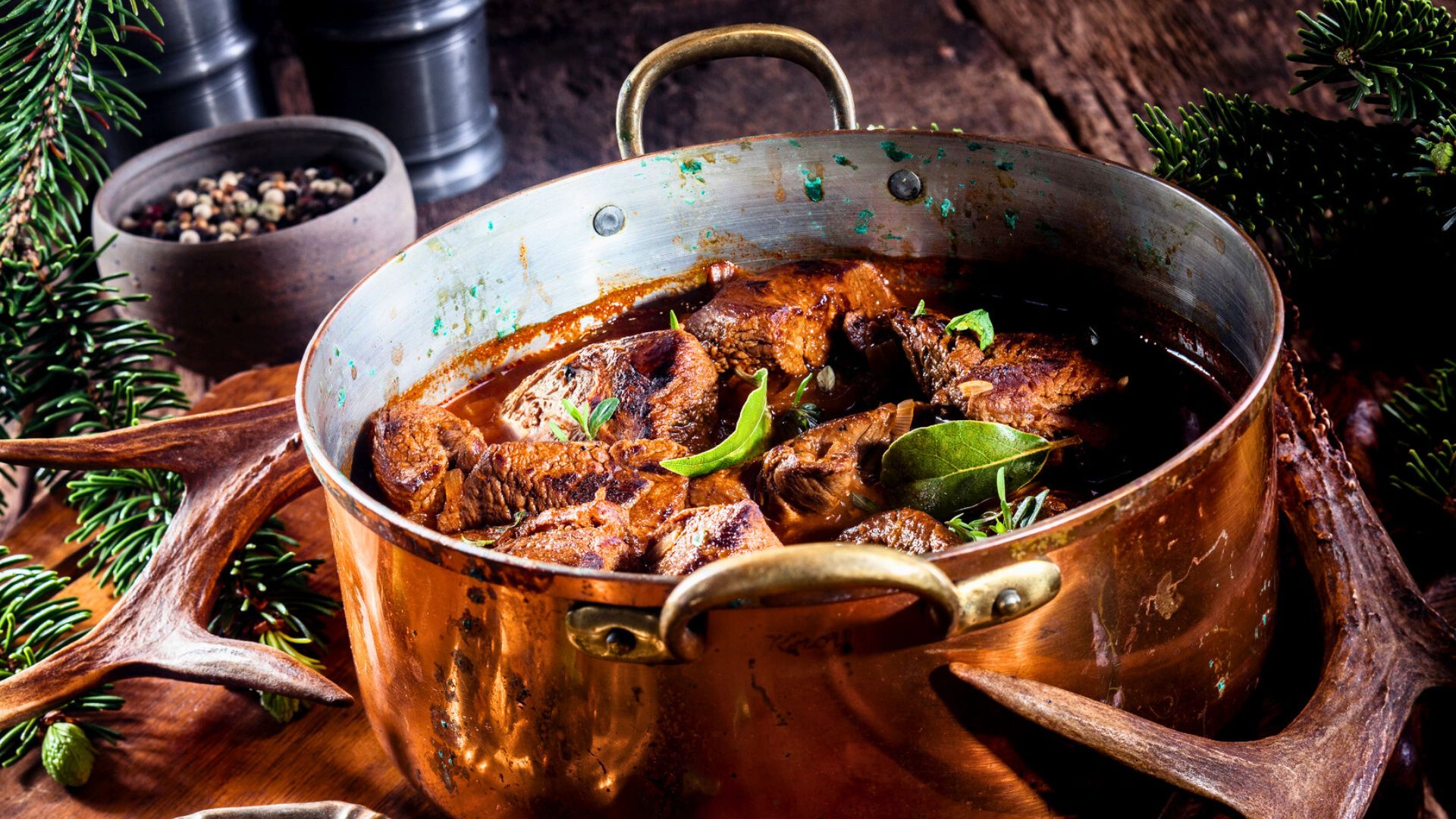 Herzhaftes Wildgulasch in Kupfertopf – zart geschmortes Fleisch in dunkler Sauce