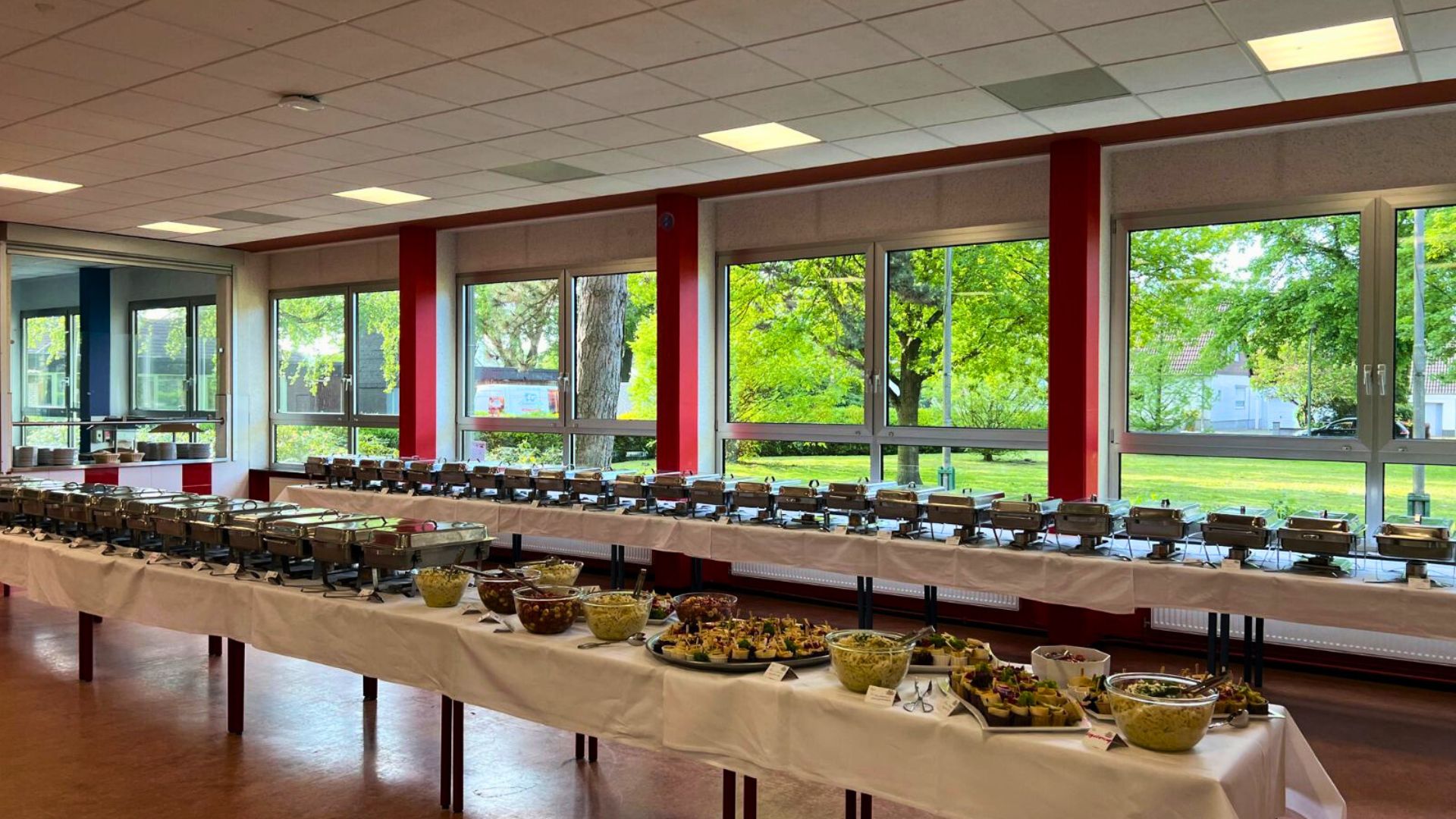 Festlich gedecktes Buffet in einem hellen Raum mit großen Fenstern