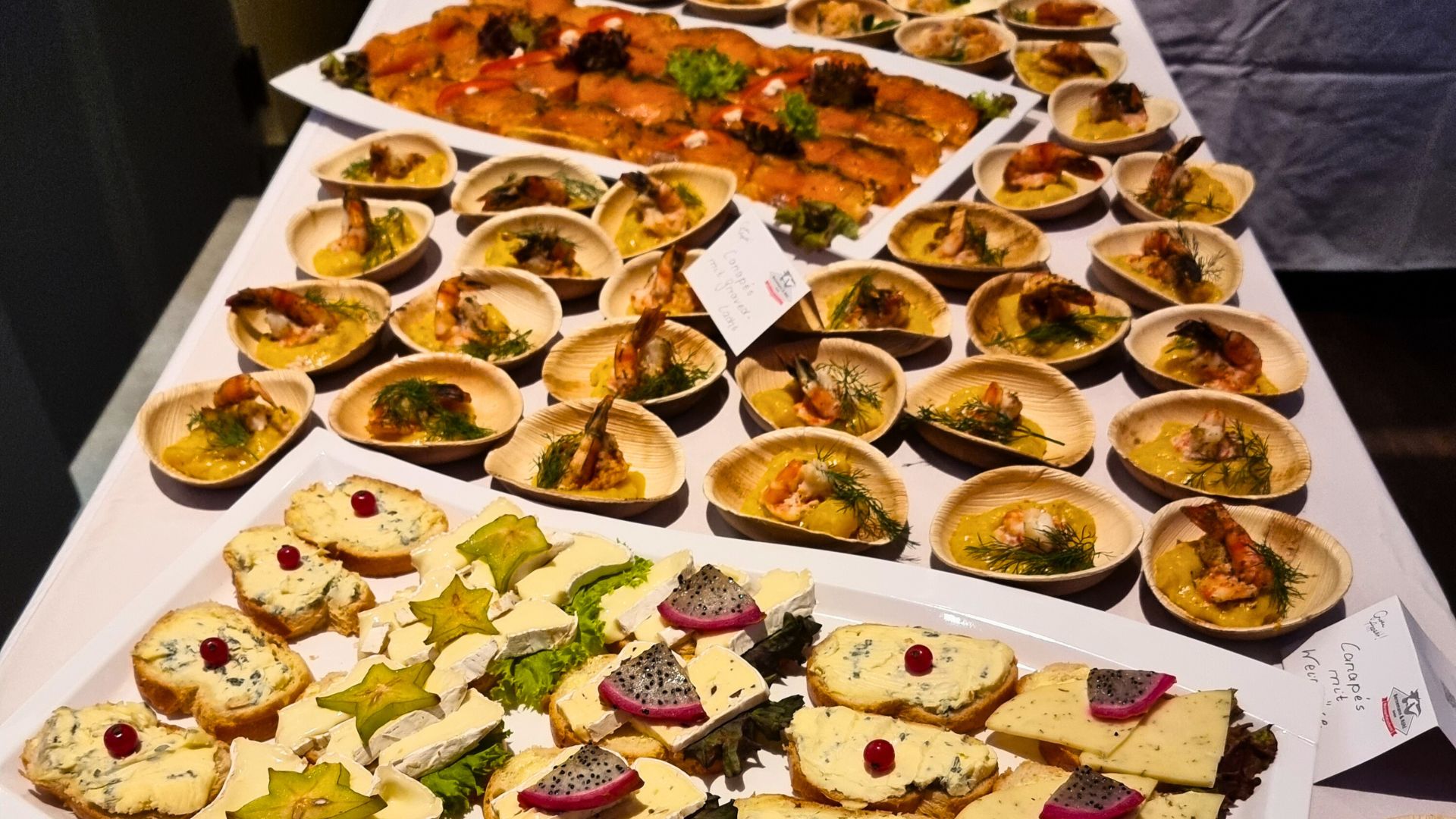 Vielfältiges Buffet mit Canapés, Käsehäppchen und Garnelen auf Mango-Curry-Sauce