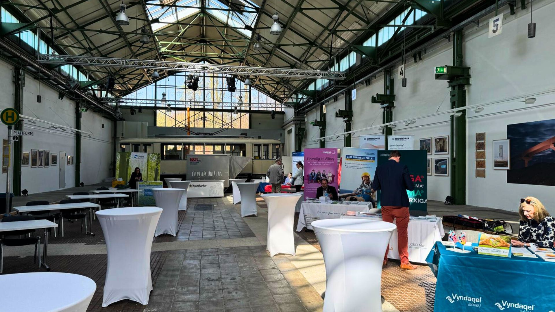 Veranstaltungshalle mit Stehtischen und Infoständen