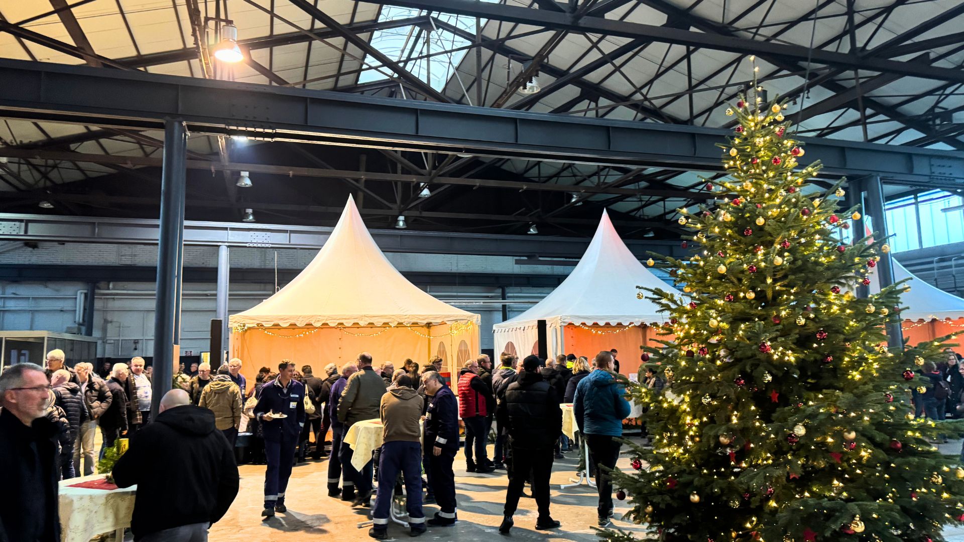 Weihnachtsfeier in einer Industriehalle mit geschmücktem Weihnachtsbaum