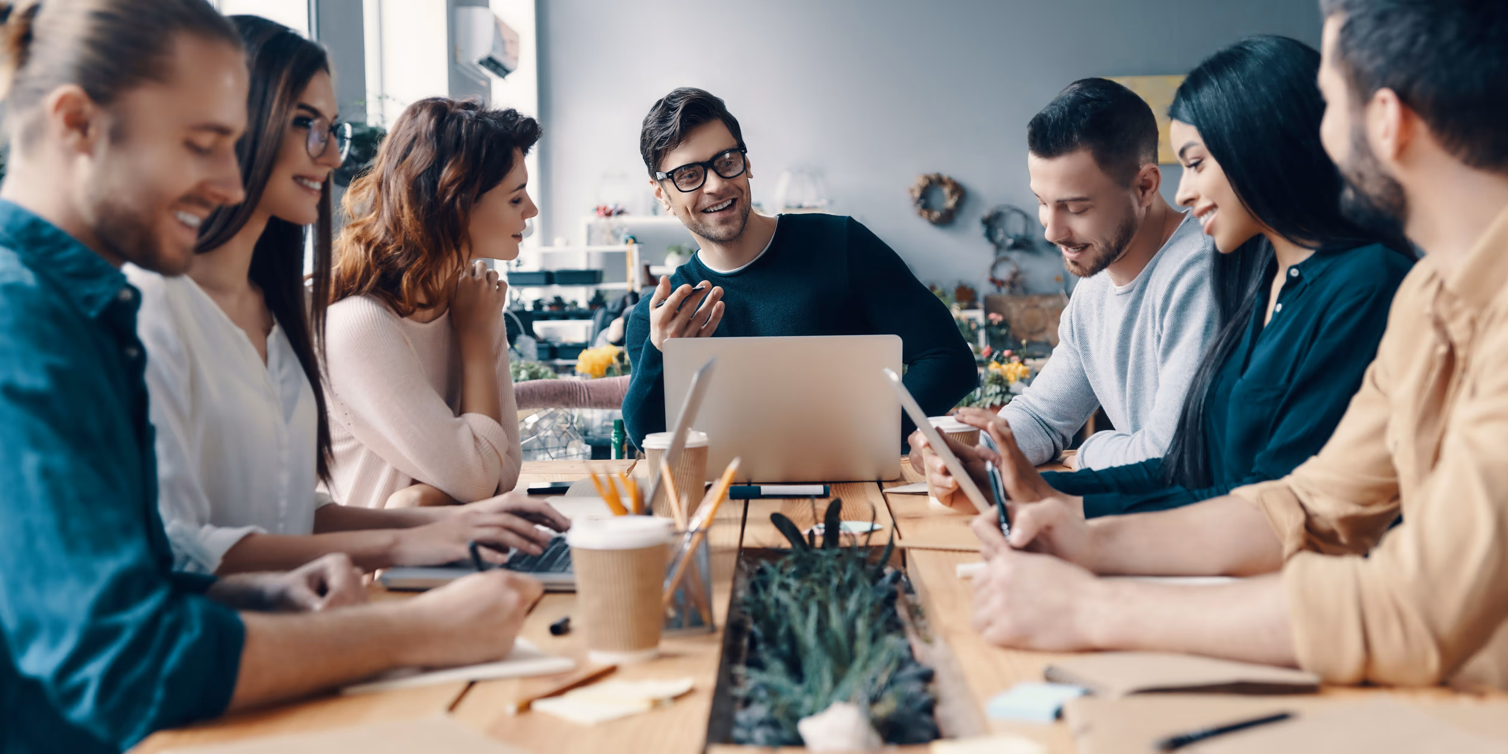 First Technology group of co workers meeting around table
