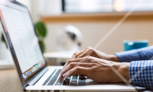 Close-up of hands typing on a laptop - First Technology Cyber Security