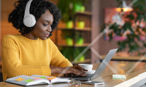 Woman weaing headphones typing a laptop - First Technology Cyber Security Solutions