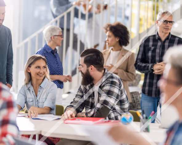 A busy office environment with multiple men and women engaged in discussions