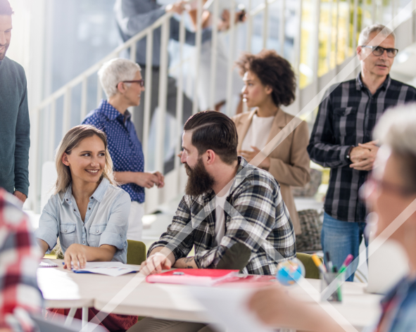 A busy office environment with multiple men and women engaged in discussions