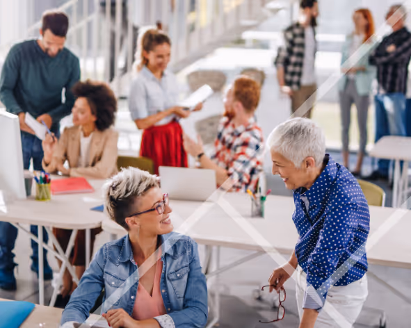 A busy office with men and women engaging in conversations