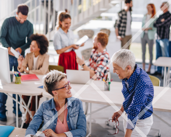A busy office with men and women engaging in conversations
