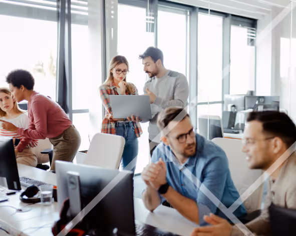 An office with men and women working together and talking