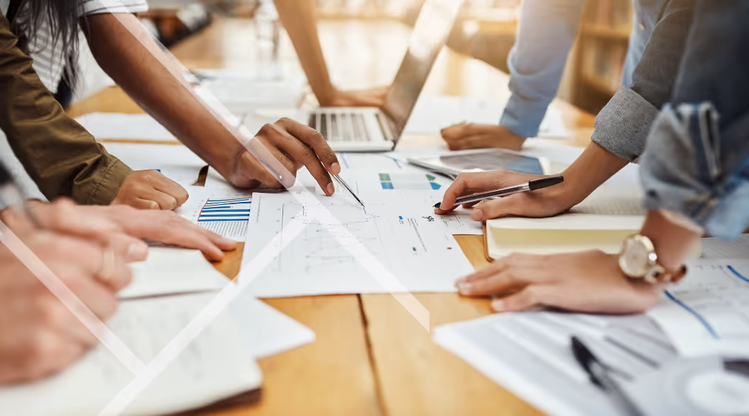 First Technology group of hands around a business table
