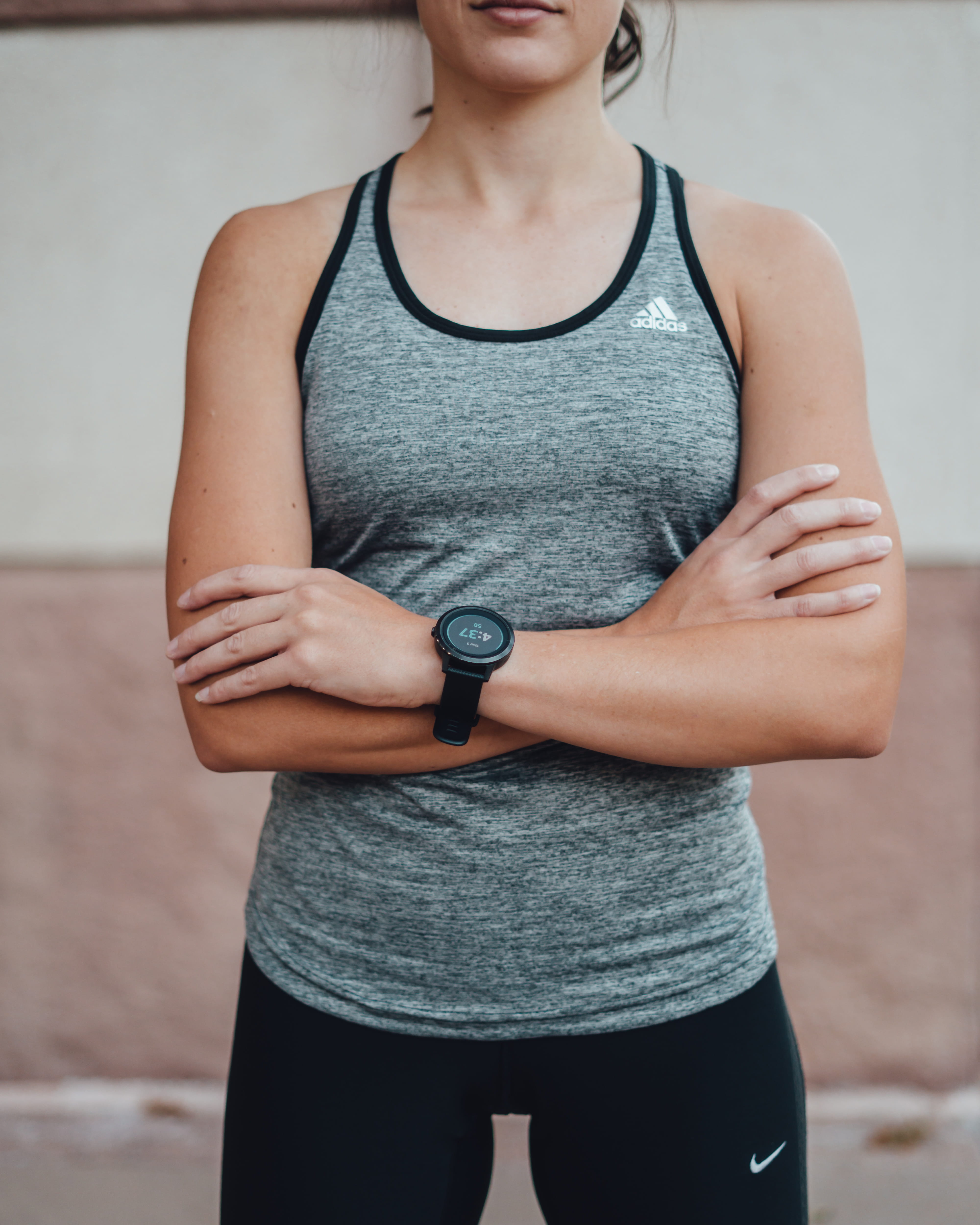 personal trainer standing with arms crossed to show Garmin watch