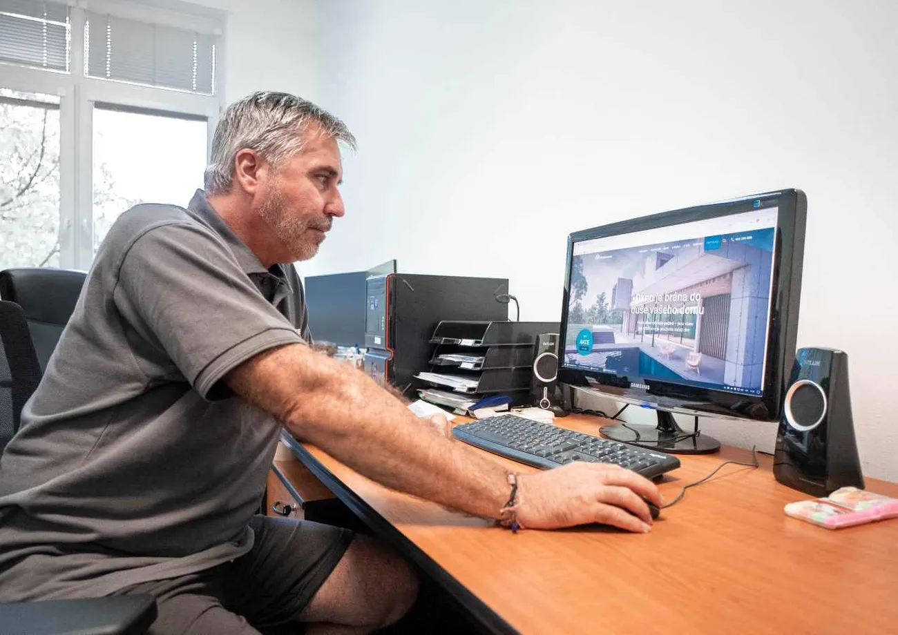 Muž pracuje u počítače v kanceláři