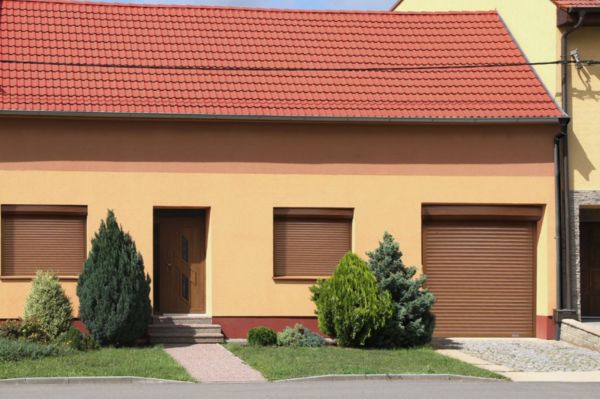 Rodinný dům s rolovacími vraty a okna s venkovními roletami ve stejné barvě