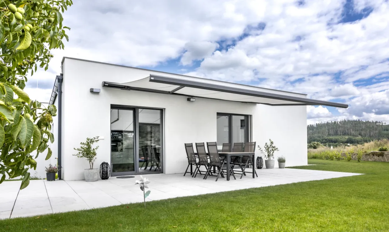 Moderní bungalov s antracitovým portálem a markýzou