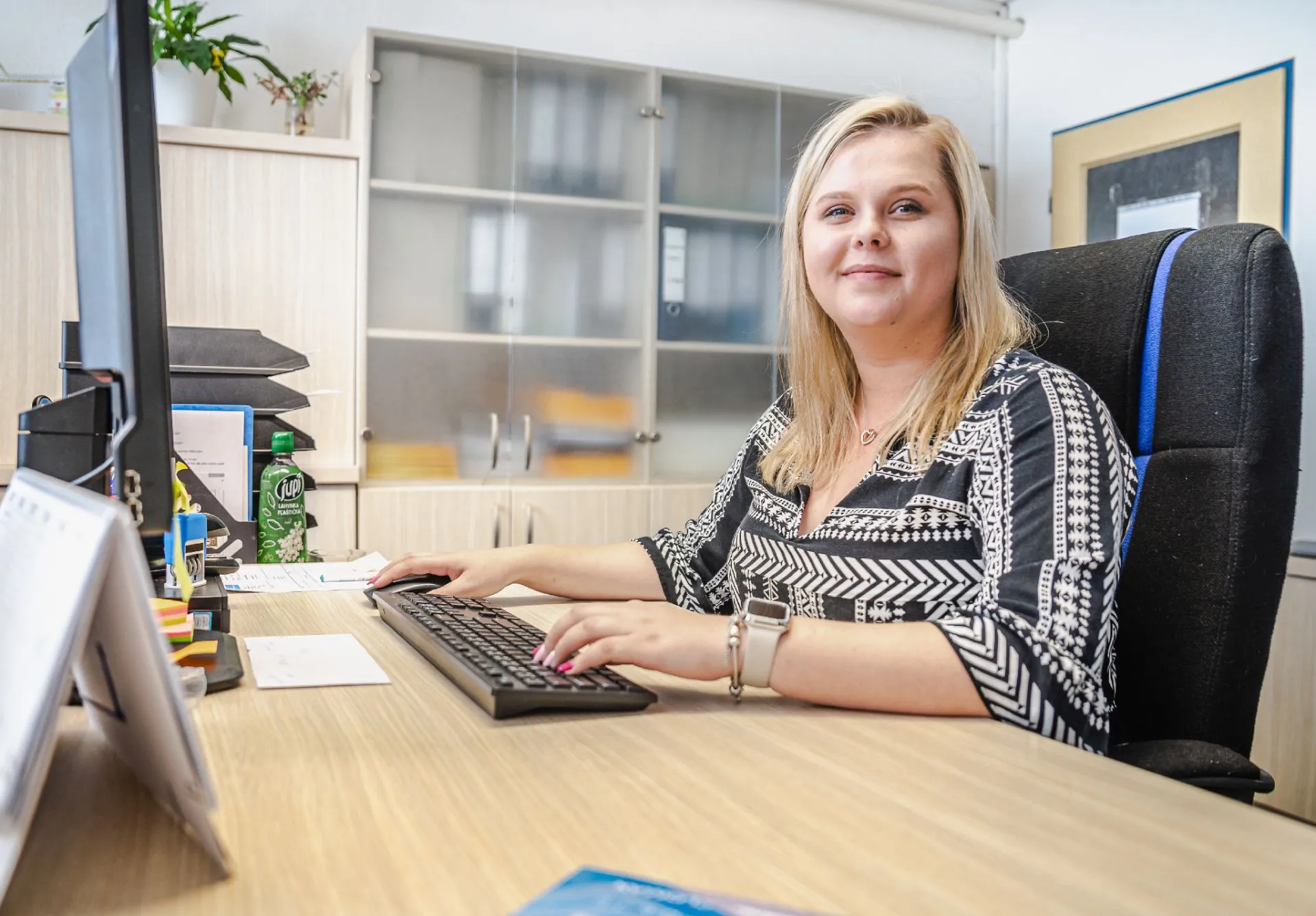 Mladá žena sedí u počítače a pracuje