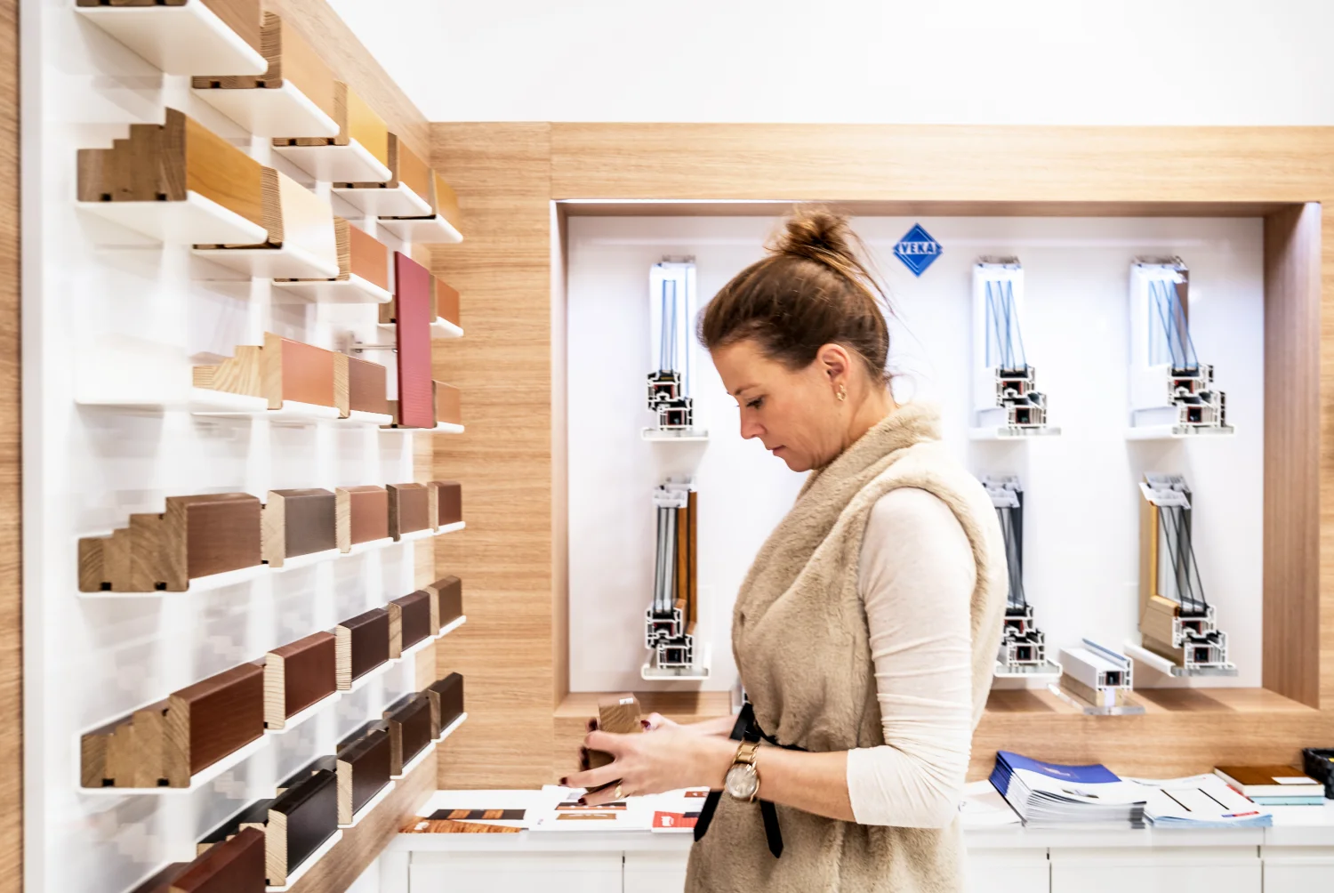 Žena si vybírá barvu okna ze vzorníku v showroomu