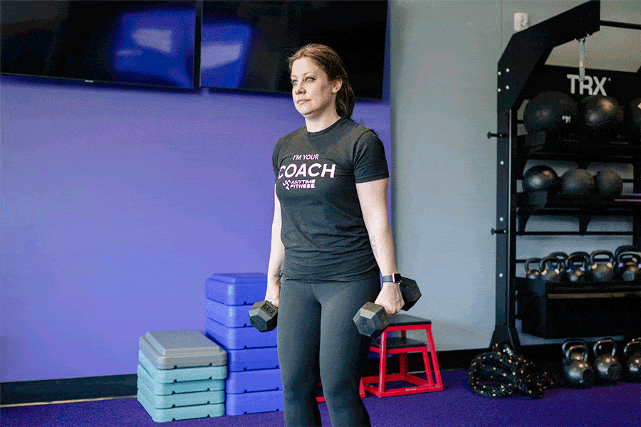 Anytime Fitness Coach demonstrating hammer curls.
