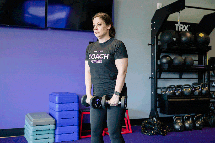 Anytime Fitness Coach demonstrating reverse grip bicep curls.