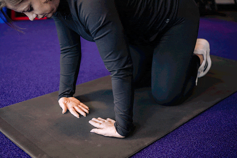 Anytime Fitness Coach demonstrating how to do a lateral wrist flexion stretch.
