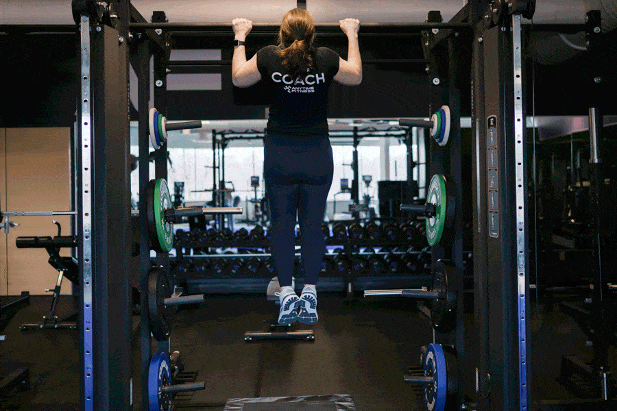 Anytime Fitness Coach demonstrating how to do negative pull-ups.
