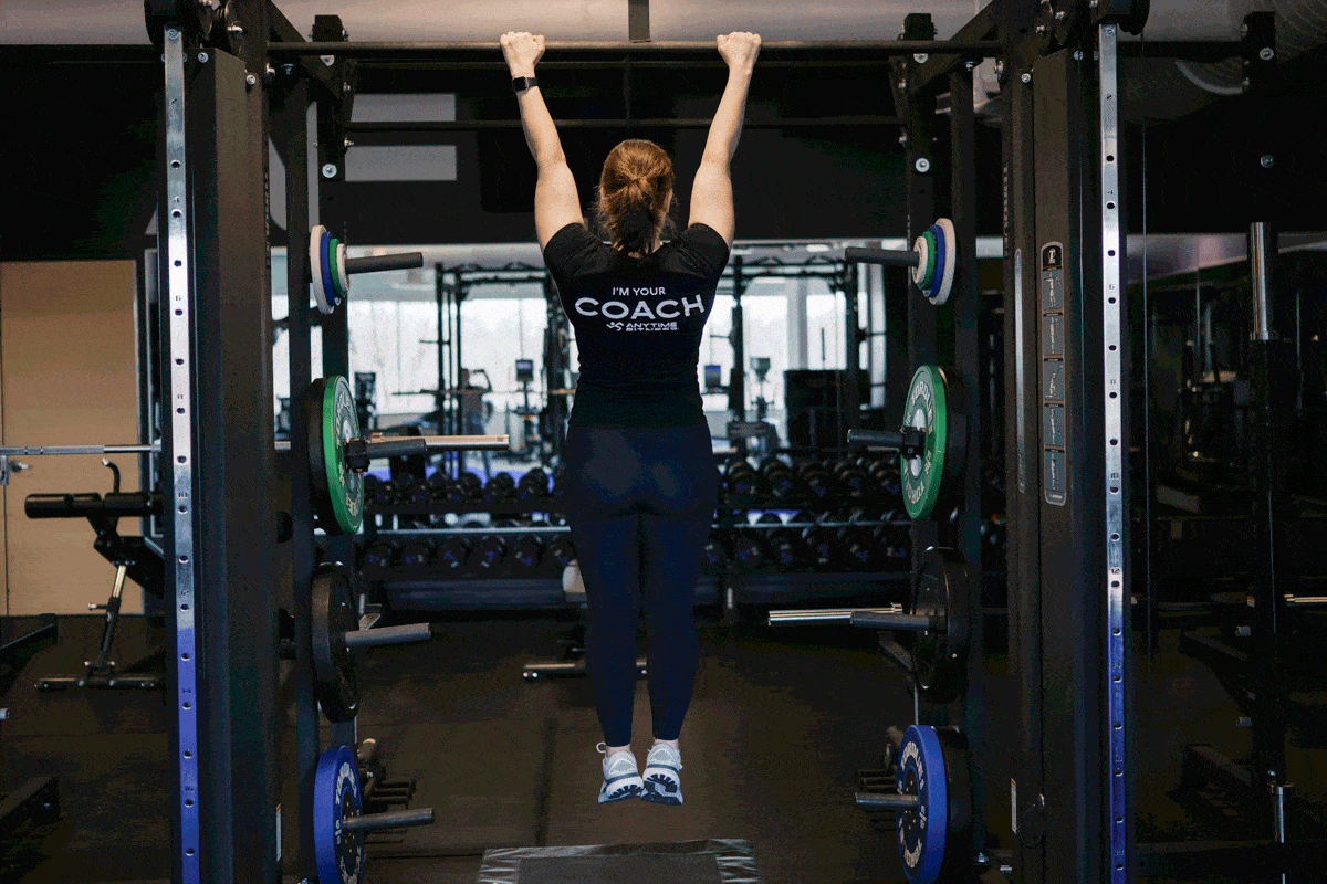 Anytime Fitness Coach demonstrating how to do scapular pull-ups.