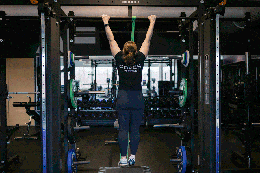 Anytime Fitness Coach demonstrating how to do band-assisted pull-ups.