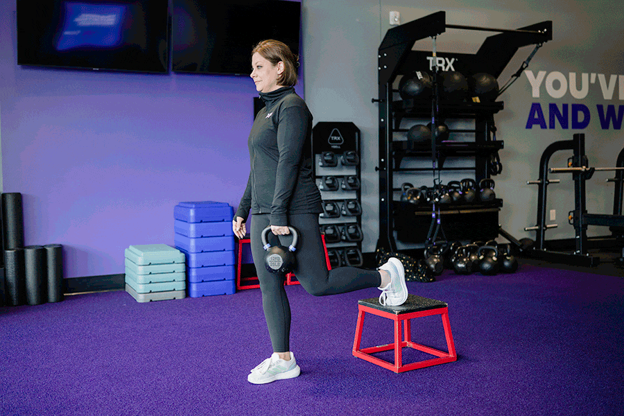 Anytime Fitness Coach demonstrating how to do a rear-foot elevated single-leg RDL.