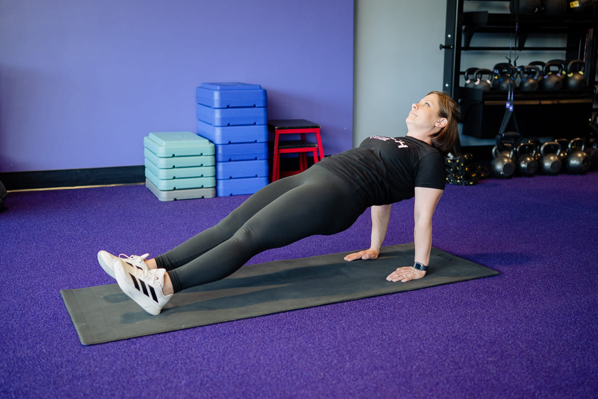Anytime Fitness Coach demonstrating a reverse plank.