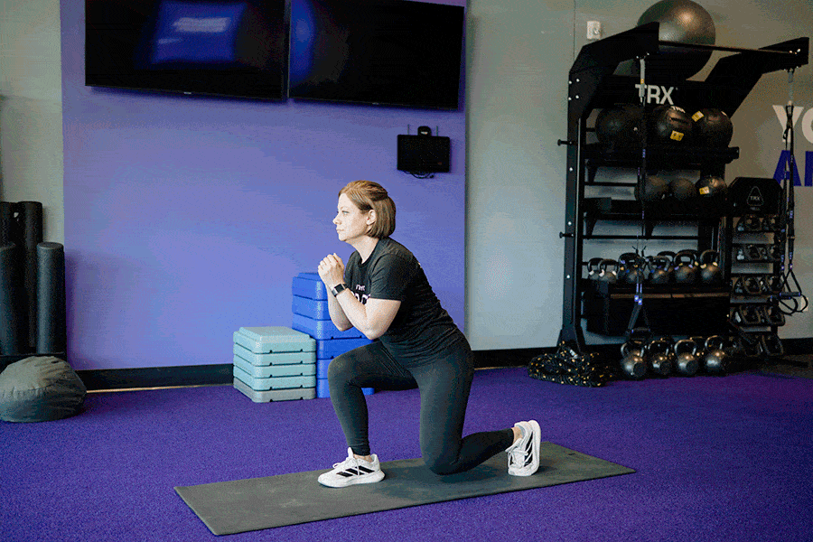 Anytime Fitness Coach demonstrating a jump lunge.