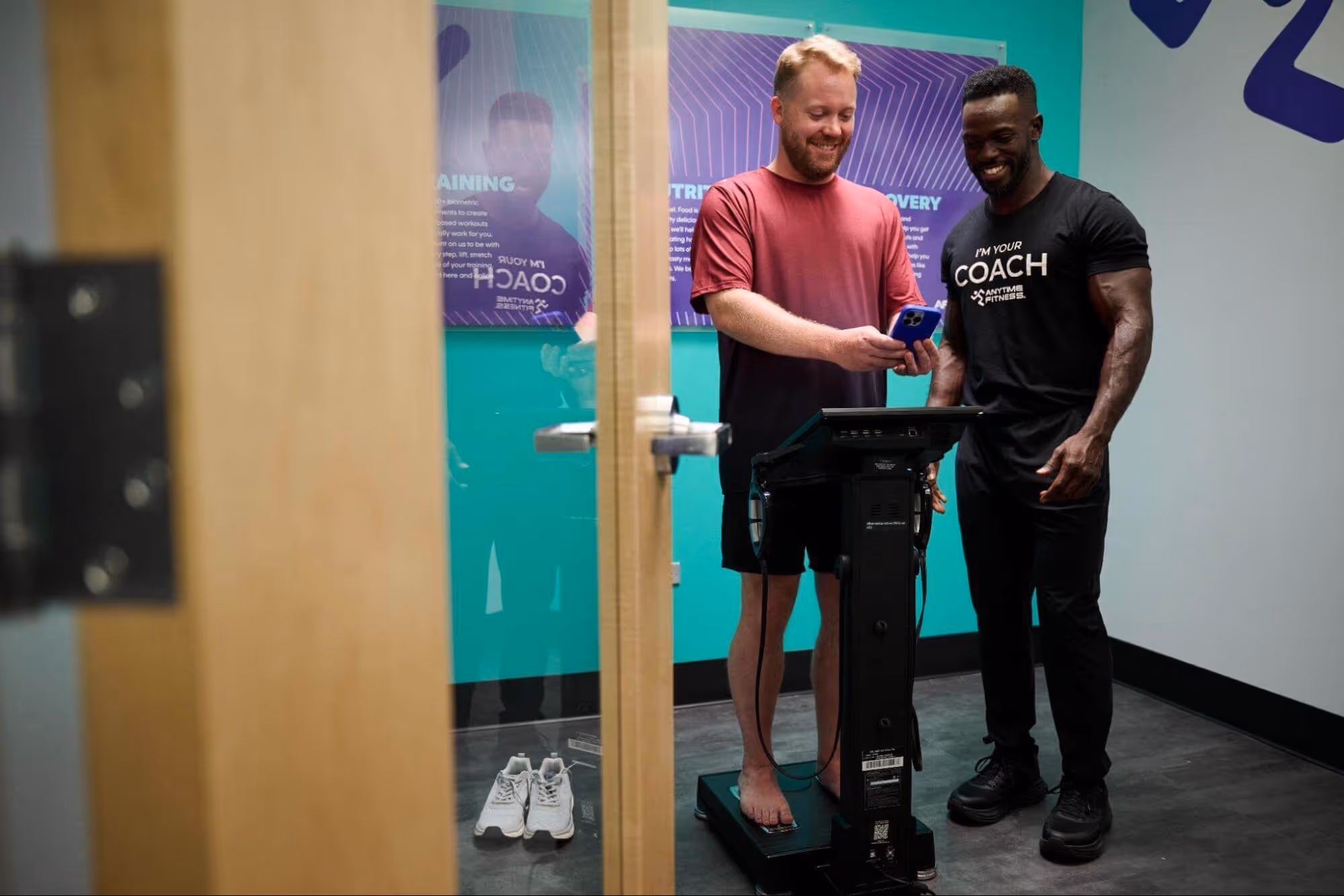 Anytime Fitness Coach working with a gym member and conducting an Evolt 360 body composition scan.