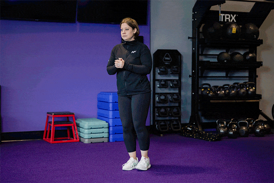 Anytime Fitness Coach demonstrating hip mobility exercises, including standing hip circles.