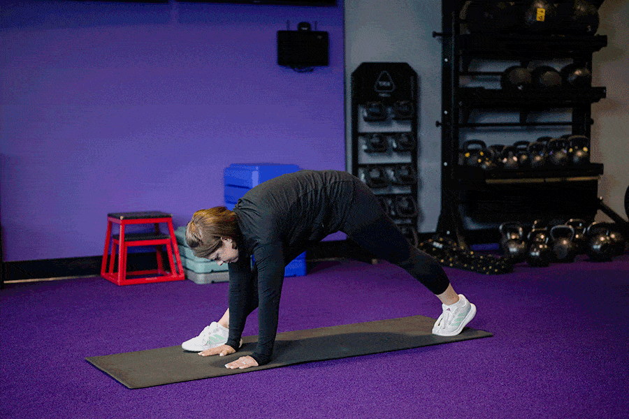 Anytime Fitness Coach demonstrating hip mobility exercises, including a Spiderman hip hinge with rotation.