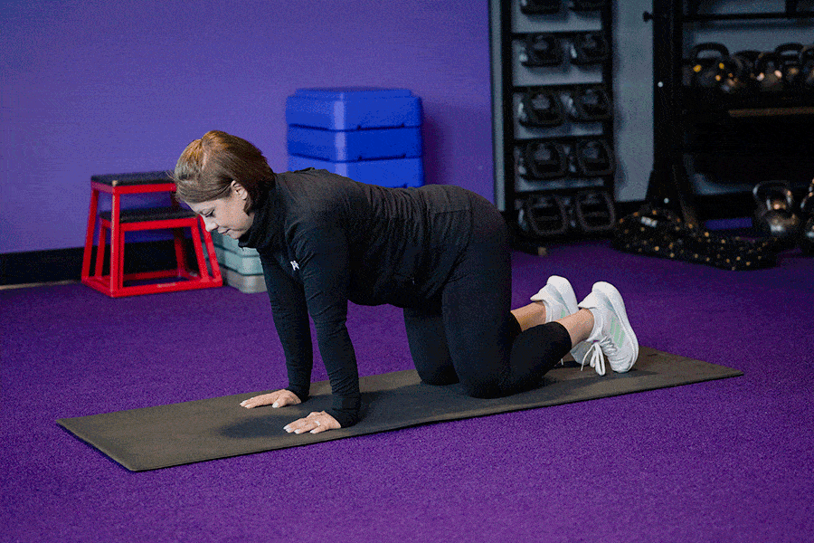 Anytime Fitness Coach demonstrating hip mobility exercises, including tabletop hip abduction (fire hydrants).