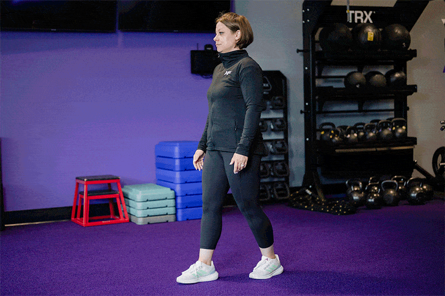 Anytime Fitness Coach demonstrating hip mobility exercises, including a split stance hip hinge.