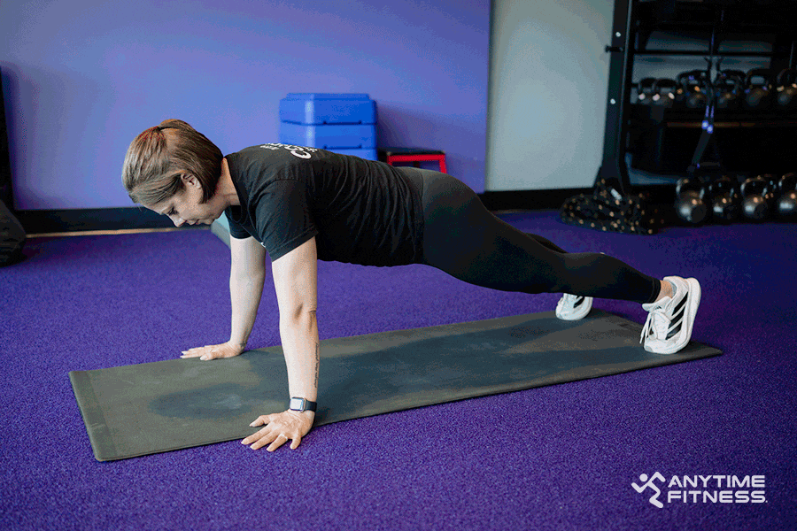 An AF Coach performs a push-up.