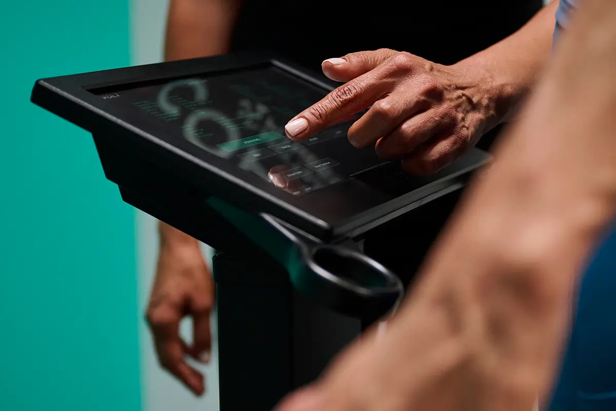 Anytime Fitness Coach using an Evolt 360 body composition scanner to show a member insights that help her navigate perimenopausal weight gain.