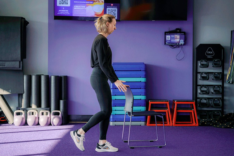 Anytime Fitness Coach demonstrating step-back lunges, a strength and balance exercise.