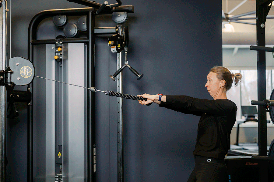 Anytime Fitness Coach demonstrating face pulls on a cable machine.