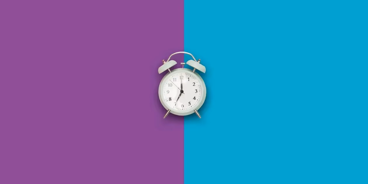 A mint green vintage alarm clock centered on a split purple and blue background, illustrating the best time to visit the gym for a workout.
