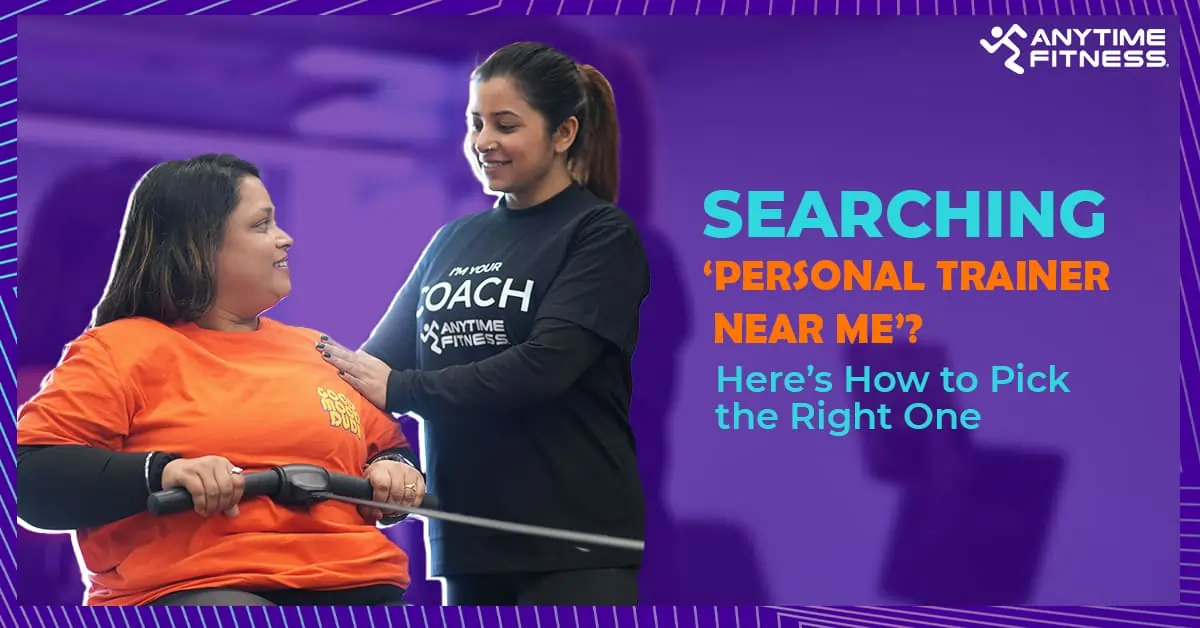 Anytime Fitness trainer assisting a woman using gym equipment with text ‘Searching Personal Trainer Near Me? Here’s How to Pick the Right One’.