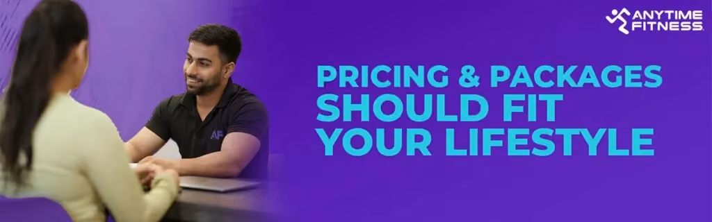 Anytime Fitness banner with the text "PRICING & PACKAGES SHOULD FIT YOUR LIFESTYLE." The left side shows a smiling consultant in a black polo shirt discussing options with a client across a desk.