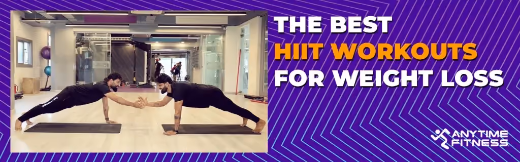 Anytime Fitness blog banner titled "THE BEST HIIT WORKOUTS FOR WEIGHT LOSS." The visual shows two men facing each other in high plank positions on yoga mats, performing a partner-based exercise by high-fiving in a spacious, modern gym.
