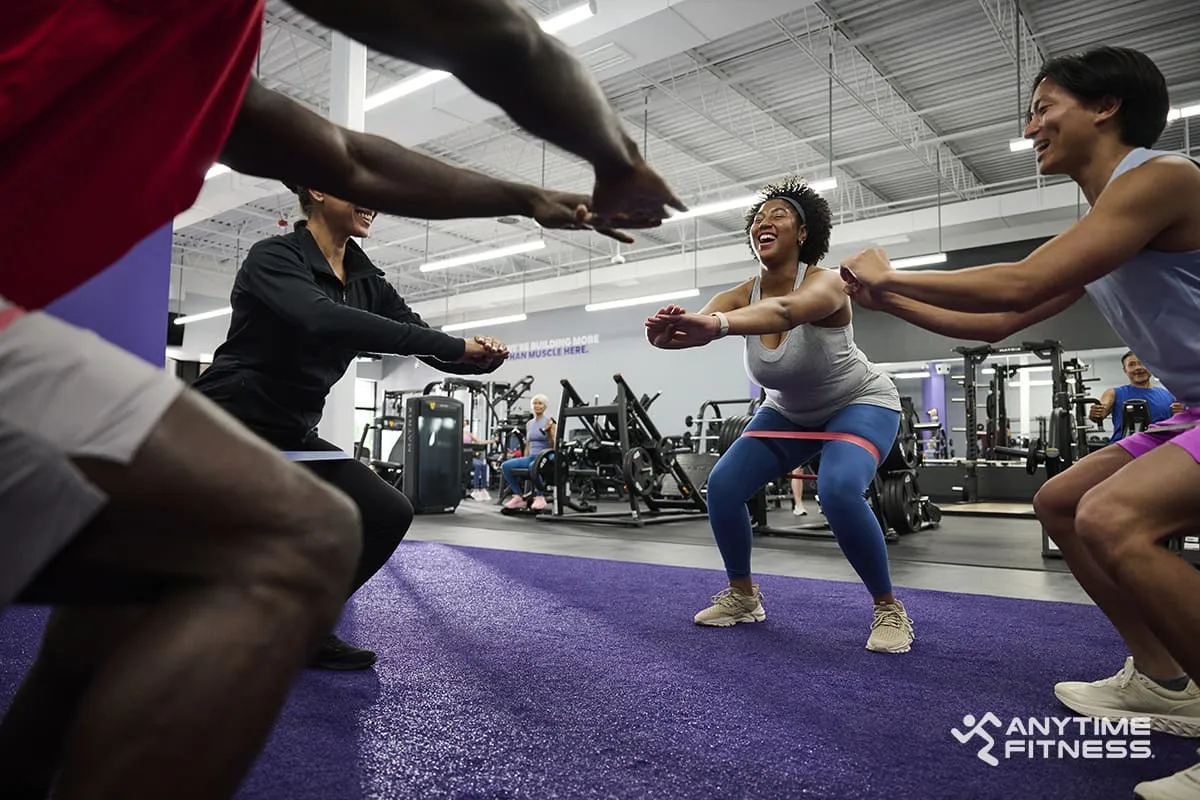 A group of AF members are doing a training session in a circle using resistance bands.