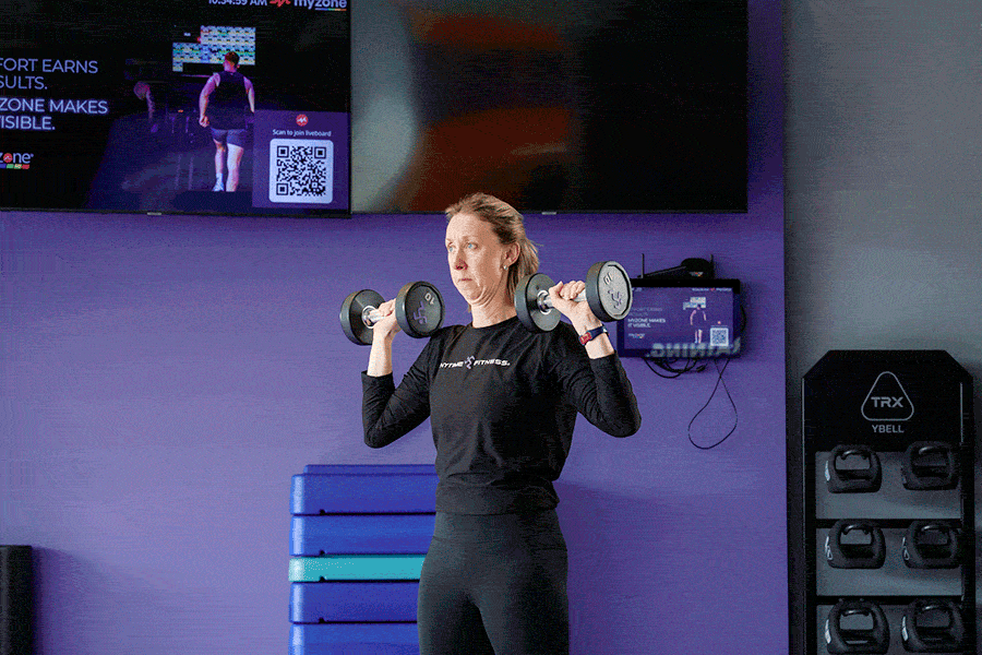 An AF Coach is doing the overhead press.