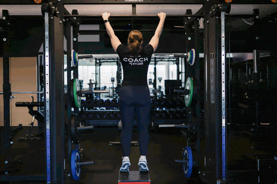 An AF Coach is doing pull-ups.