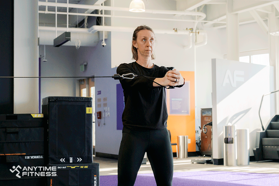 Anytime Fitness Coach demonstrating a Palloff press, a cable machine exercise.