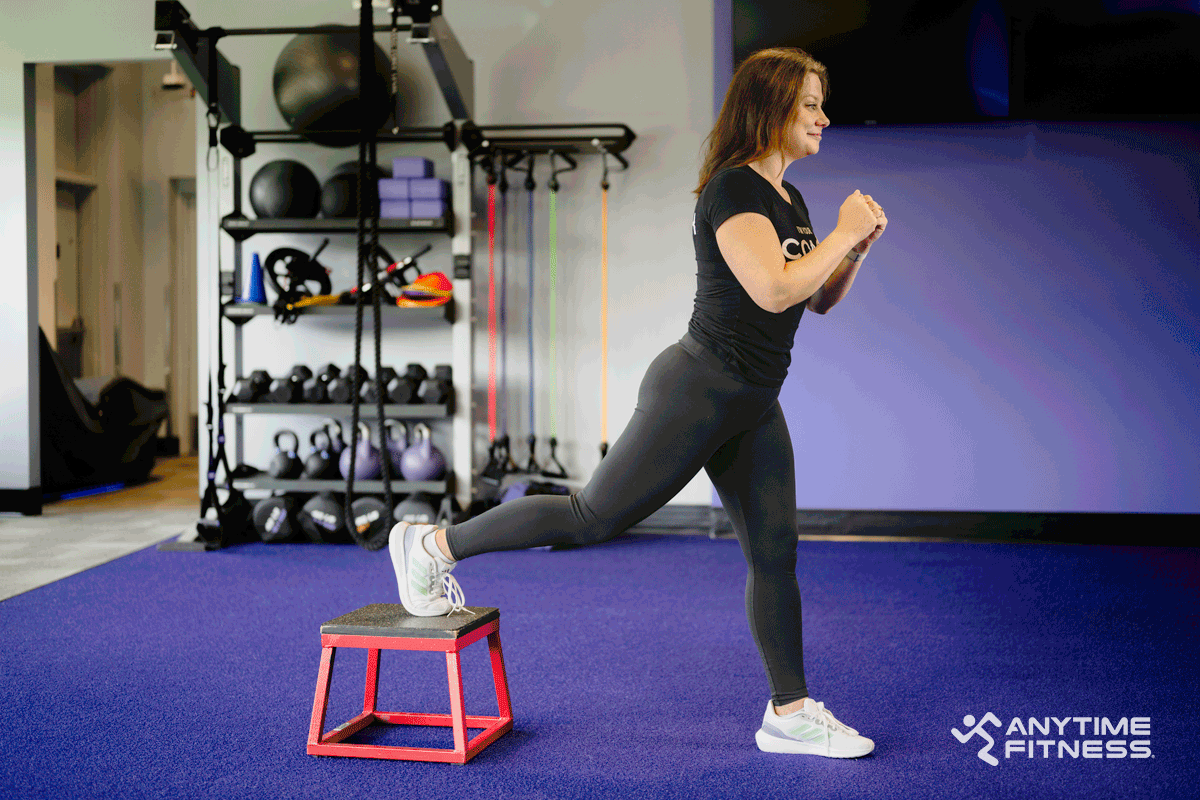 Anytime Fitness Coach demonstrating a Bulgarian split squat. 