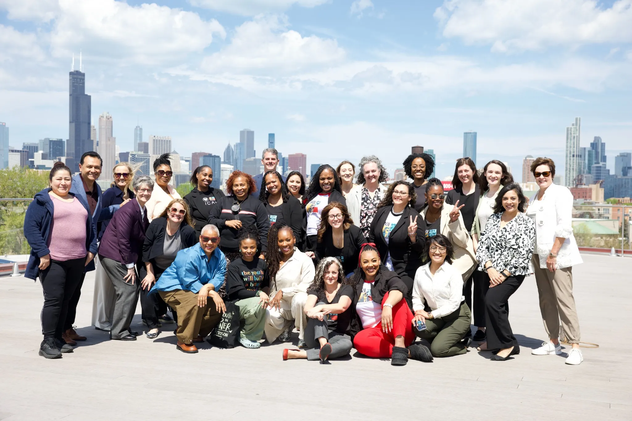 Women's Justice Commission members gathered for a group photo on a rooftop with the Chicago skyline behind them.