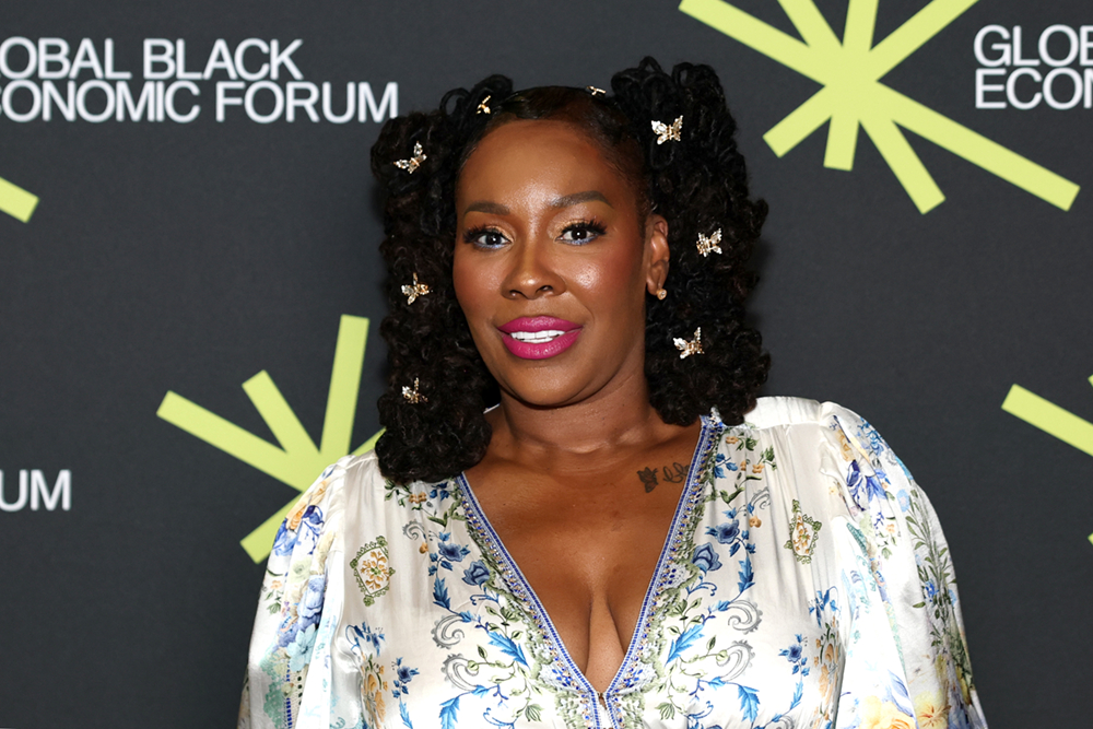 Dr. Topeka K. Sam in a floral dress at the Global Black Economic Forum step and repeat.